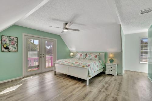a bedroom with a bed and green walls and wooden floors at Jensen Beach Tropical Resort in Fort Pierce