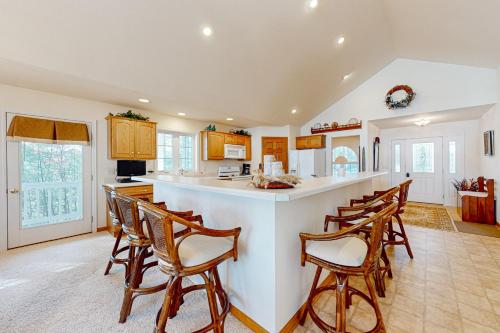 a large kitchen with a bar with wooden chairs at Yellow Birch Memories in Eagle River