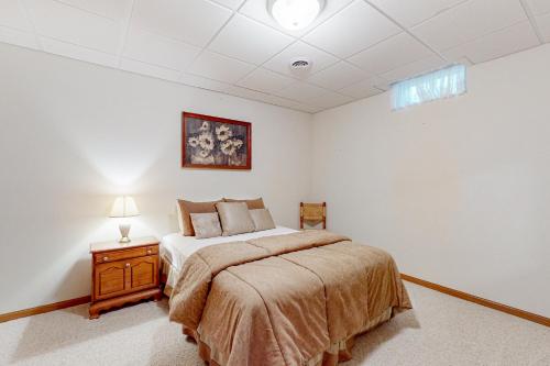 a bedroom with a bed and a table with a lamp at Yellow Birch Memories in Eagle River