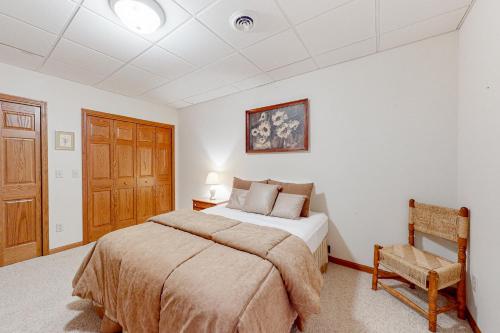 a bedroom with a bed and a chair in it at Yellow Birch Memories in Eagle River