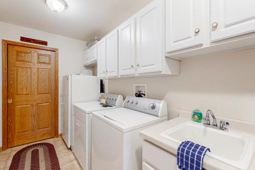 a kitchen with a washer and dryer and a sink at Yellow Birch Memories in Eagle River