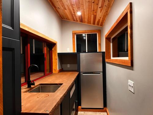 a kitchen with a stainless steel refrigerator and a sink at Magical Yurt in the woods - 2 miles from town in Nevada City