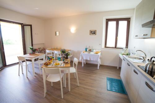 una cucina e una sala da pranzo con tavolo e sedie di B&B Isa a Loreto