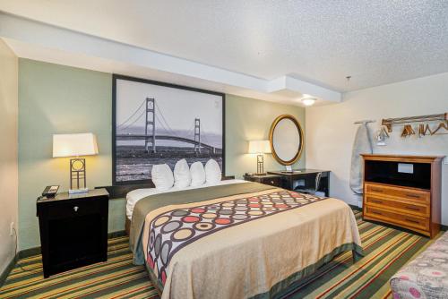 a hotel room with a large bed and a bridge at Super 8 by Wyndham Mt. Pleasant in Mount Pleasant