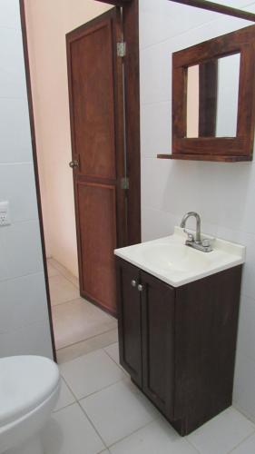 y baño con lavabo, aseo y espejo. en Hab #3 La Casa Del Profe Salo, en Zapote