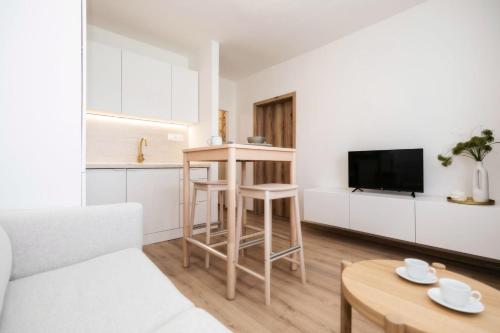 a living room with a kitchen and a table at Bonnie&Beauty apartment in Banská Bystrica