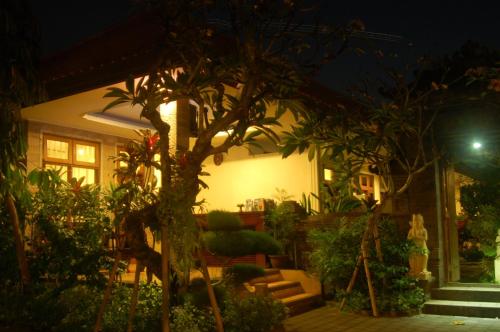 a house with a lot of plants in front of it at Gunakaya Homestay in Sanur