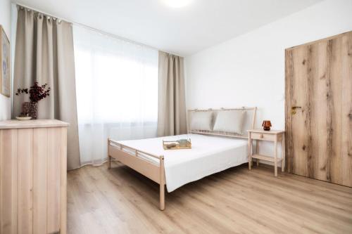 a bedroom with a white bed and a window at Bonnie&Beauty apartment in Banská Bystrica