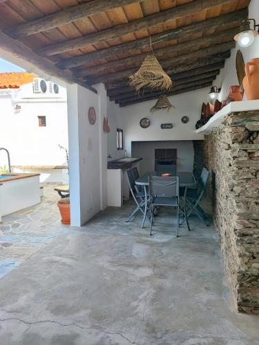 a living room with a table and chairs and a stone wall at Casa Tia Xica in Monsaraz
