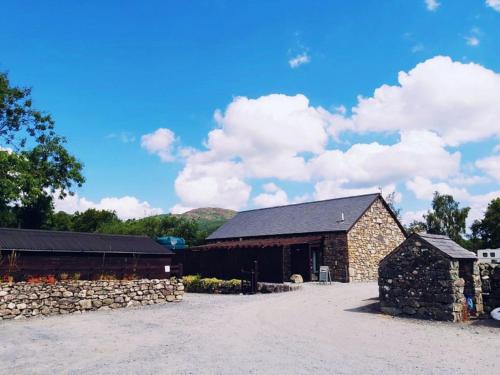 a barn with a stone wall next to a building at Private Room at Torrent Walk Bunkhouse in Snowdonia in Dolgellau