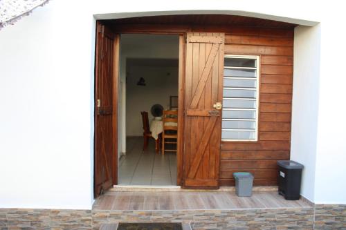 an open door of a house with a table at Villa Le Gommier, Meublé de tourisme 3 étoiles in Le Moule