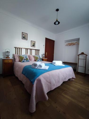 a bedroom with a large bed with two towels on it at Casa Tia Xica in Monsaraz