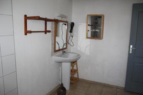 uma casa de banho com um lavatório branco e um espelho. em Villa Le Gommier, Meublé de tourisme 3 étoiles em Le Moule