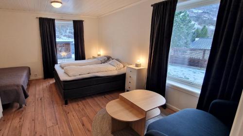 a bedroom with a bed and a couch and a window at Otnes Fjordside in Aurland