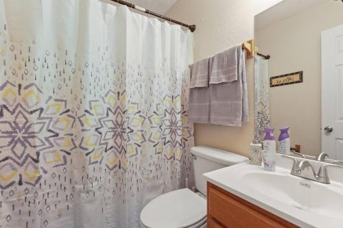 a bathroom with a toilet and a shower curtain at Cottage in Diamondhead in Diamondhead