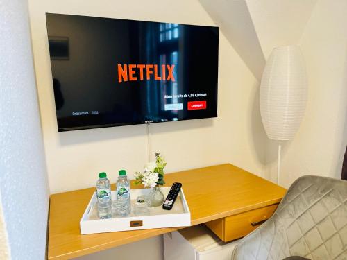 a room with a tv and a table with water bottles at Pension Maria in Rochlitz