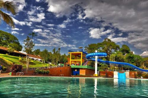 una piscina con un tobogán de agua en un parque en CLUB CAMPESTRE EL BOSQUE, en Silvania