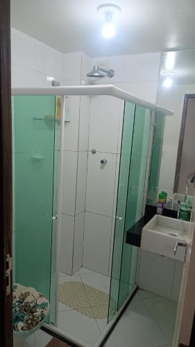 a glass shower in a bathroom with a sink at apartamento em Jacumã in Jacumã
