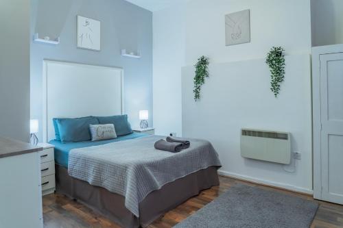 a bedroom with a bed with blue walls and a mirror at 1 bedroom flat in City Centre in Birmingham