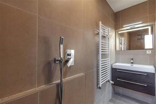 uma casa de banho com um chuveiro e um lavatório. em Charmante villa des années 30 em Abeiche