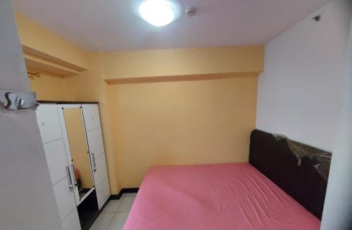 a bedroom with a pink bed in a room at Apartemen green bay pluit in Jakarta