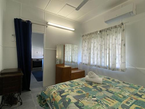 a bedroom with a bed and a room with a kitchen at Whitehaven 2 in Picnic Bay
