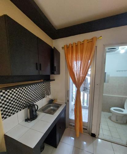 a kitchen with a sink and a shower curtain at Apartemen green bay pluit in Jakarta