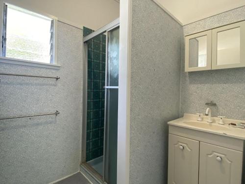 a bathroom with a shower and a sink at Whitehaven 2 in Picnic Bay