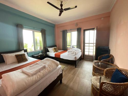 DeorāliにあるHimalaya Serene View Guest House & Farm Stayのベッドルーム1室(ベッド2台、シーリングファン付)