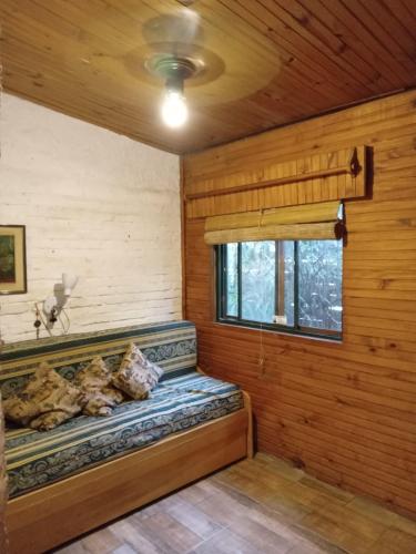 Habitación con cama en una cabaña de madera en Casa en Costa Azul - Canelones, en La Floresta
