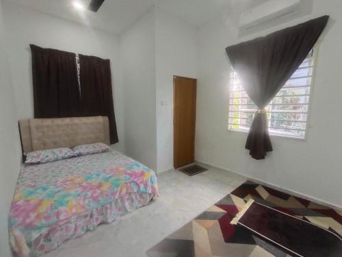 Schlafzimmer mit einem Bett und einem Fenster in der Unterkunft Mie Homestay in Pasir Mas