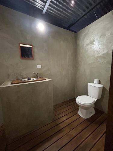 a bathroom with a toilet and a sink at Pyramid Tamarindo Luxury Hotel in Tamarindo