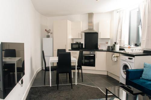 a kitchen and dining room with a table and chairs at Charming and Bright 2 Bedroom Apartment, Close to Stadiums, Transport links, Free Parking in Manchester