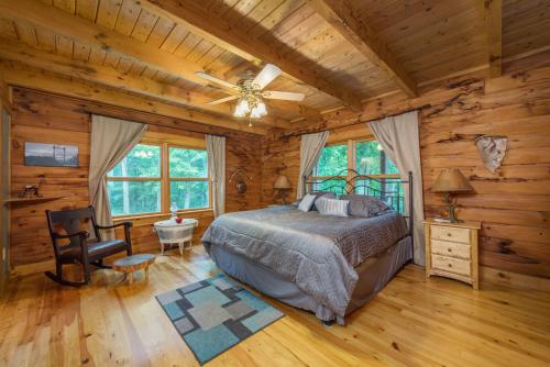 a bedroom in a log cabin with a bed and a ceiling fan at Shadow Ridge Retreat Pet Friendly and Views in Fletcher