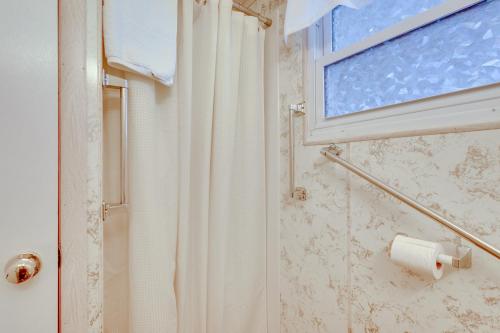 een badkamer met een douchegordijn en een raam bij Cozy Huntingdon Escape 19 Mi to Penn State Univ! in Huntingdon
