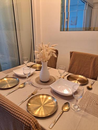 a dining table with plates and silverware on it at La Casa Ysabela - Azure Affordable Staycation, Paranaque Metro Manila in Manila