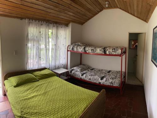 1 dormitorio con 2 literas y ventana en CLUB CAMPESTRE EL BOSQUE, en Silvania