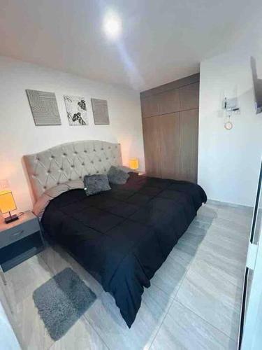 a bedroom with a large black bed in a room at Loft Marina Cerritos in Mazatlán