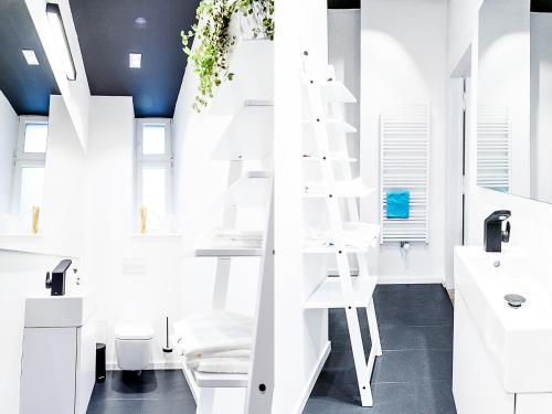 a white bathroom with a white ladder in it at Boom Apartments in Kraków