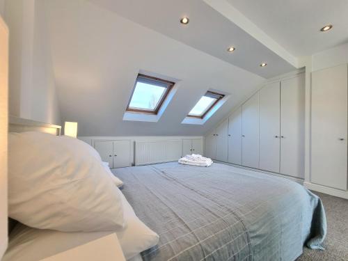 a bedroom with a bed and two skylights at The Loft in London