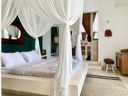 1 dormitorio con 1 cama con cortinas blancas en Villa great location in Bali, en Kerobokan