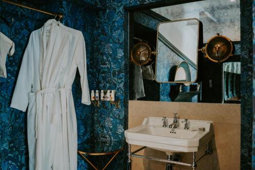 a bathroom with a sink and a white robe at HIGHFIELD in Great Driffield
