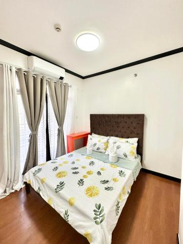 a bedroom with a bed with a floral bedspread at Caiden's Home in Davao City
