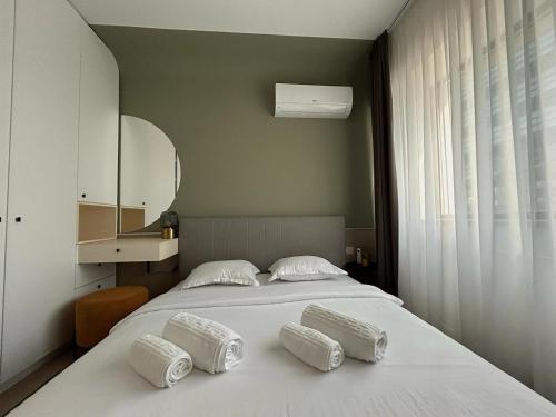 a bedroom with a bed with three pillows on it at Interio Apartament PREMIUM in Cortina North in Bucharest