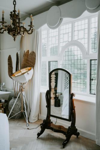 a mirror and a chair in a room with windows at HIGHFIELD in Great Driffield