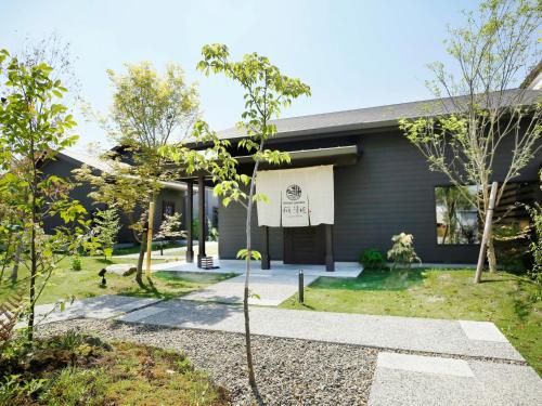une maison avec un panneau à l'avant dans l'établissement 湯本庵清姫, à Kirishima