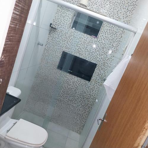 a bathroom with a shower with a toilet and a television at à 5 minutos do Parque do Povo in Campina Grande