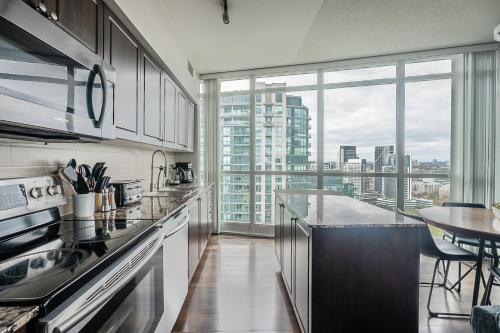 a kitchen with a view of a city skyline at RivetStays - The Neptune in Toronto