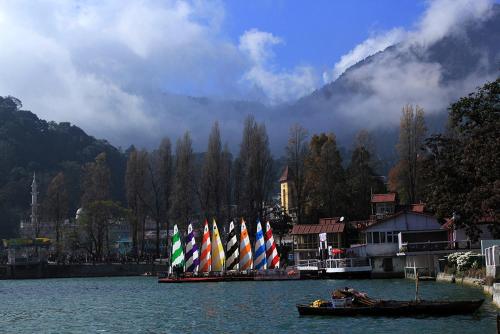 grupa łodzi z kolorowymi żaglami w wodzie w obiekcie Naini House w mieście Nainital
