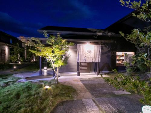 une maison avec un rideau dans la cour la nuit dans l'établissement 湯本庵清姫, à Kirishima